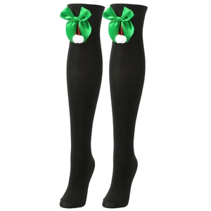 Detail of black knit over-knee socks with green satin bows and white fuzzy pom-poms