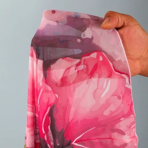 Close-up of semi-transparent pink floral mesh fabric showing detailed texture and patterns