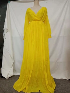 Detail of waist pleats and deep V-neck on a bright yellow floor-length maxi dress