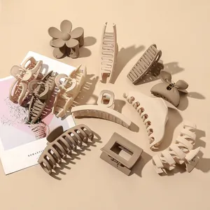 Detailed macro view of matte hair claws set in earthy tones including beige and brown colors