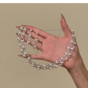 Close-up of elegant pearl and rhinestone jewelry set including necklace and earrings