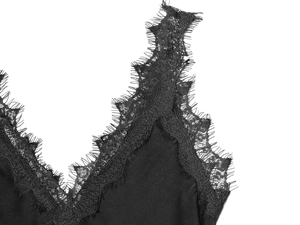 Close-up of intricate eyelash lace trim on black satin V-neckline dress bodice