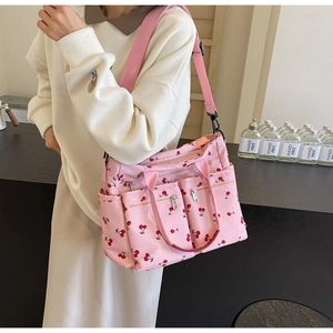 Detailed view of pink cherry print tote bag with adjustable wide fabric shoulder strap
