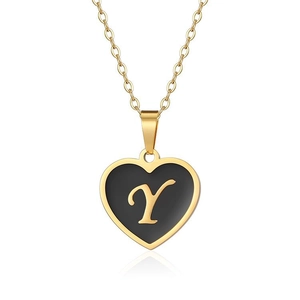Detailed macro of a gold heart pendant with black oil drip and engraved letter Y