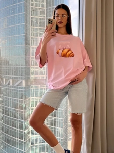 Λεπτομέρεια ροζ βαμβακερού oversized t-shirt με τύπωμα κρουασάν και κορδέλας