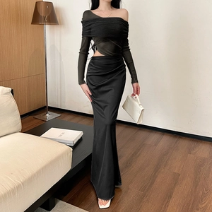 Detail of elegant black off-shoulder knit top and high-waist satin maxi skirt set