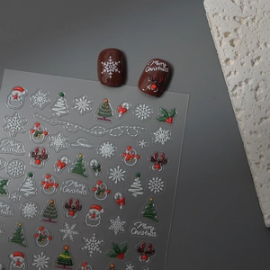 Close-up of 3D Christmas nail stickers with Santa Claus and reindeer on dark nail tips