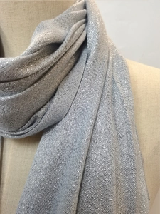 Close-up of silver glitter knit scarf showing sparkling metallic threads and fringe detail
