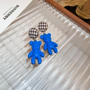Close-up of blue flocked bear earrings with houndstock fabric stud details