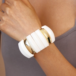 Detail of wide modular elastic bracelet featuring white acrylic and gold-tone metal segments