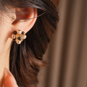 Vue macro de boucles d'oreilles fleur plaquées or avec perles et oxydes de zirconium