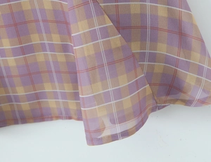 Macro shot of purple and gold plaid chiffon fabric showing fine weave texture and draping