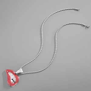 Vue détaillée d'une chaîne argentée et pendentif lèvres rouge hip-hop serti de strass