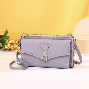 Detail of lavender pebbled leather phone bag featuring dual zippers and golden U-shaped buckle