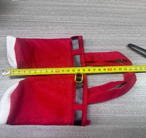 Détail du sac cadeau en forme de pantalon de Noël avec ceinture montrant la largeur de 25cm