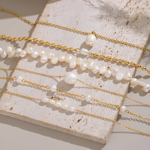 Golden stainless steel necklace and bracelet set featuring natural baroque white pearls