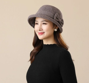 Close-up of elegant grey-brown knitted bucket hat with ribbon bow detail for women
