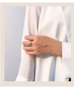 Close-up of golden double-layered geometric ring with a white pearl on a model's hand