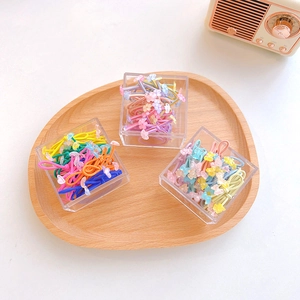 Colorful kids hair ties with cute resin flower and bear charms in a wooden tray