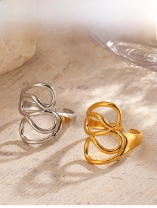 Detailed view of hollow abstract spiral rings in polished gold and silver finishes