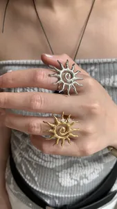 Close-up of gold and silver sunburst rings with textured radial sun ray design