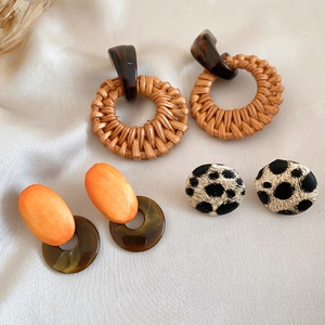 Detail of woven rattan, resin hoops, and leopard print fabric stud earring set