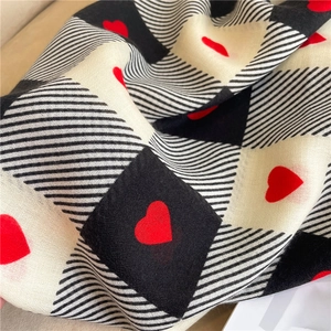 Detail shot of the checkerboard cotton linen scarf with red heart patterns and soft texture