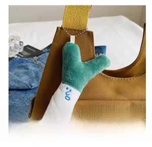 Close-up of a cute plush vegetable charm attached to a brown canvas tote bag