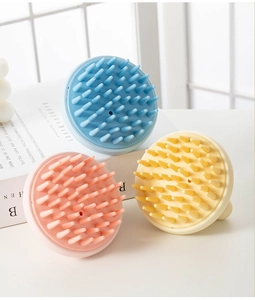 Three silicone scalp massage brushes in pastel pink blue and yellow for hair washing