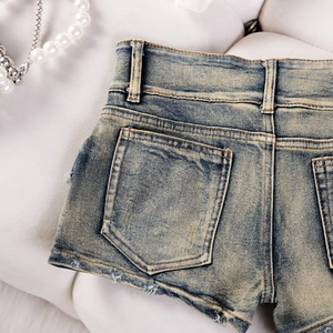 Nahaufnahme der Gesäßtasche und Distressed-Taillendetails an dunkelblauen Denim-Shorts