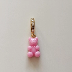 Detail of pink resin gummy bear pendant with gold clasp and sparkling zirconia stones