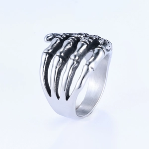Vintage stainless steel skull hand ring in punk gothic style for men on white background