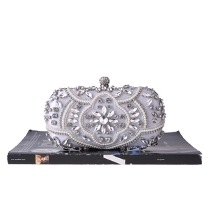 Detailed view of silver silk evening bag with intricate pearl and rhinestone embroidery