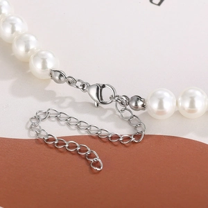 Macro shot of lobster clasp and extension chain on pearl cuban link necklace