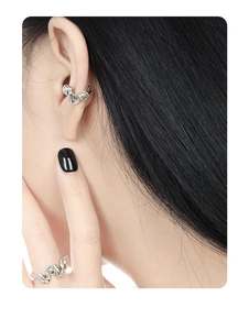 Detailed shot of silver wave ring and ear cuff set with sparkling yellow diamonds