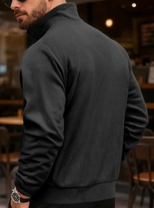 Detail showing the ribbed texture and back tailoring of a black corduroy cardigan jacket