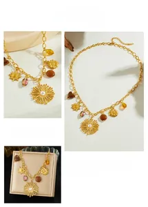 Détail du collier doré avec pendentifs soleil, cœurs en perles et perles ambrées