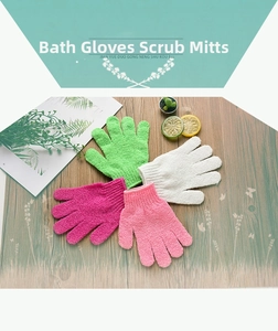 Detailed view of four colorful exfoliating five-finger bath gloves on a wooden surface