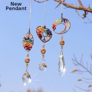 Three tree of life crystal suncatchers with colorful stones hanging under a blue sky