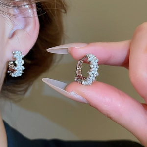 Macro shot of 14K gold plated hoop earring with white pearls and sparkling zircon stones