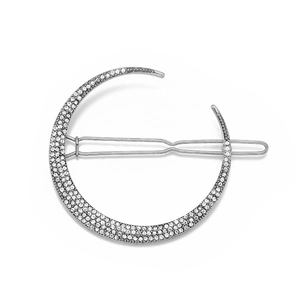 Detail of silver crescent moon hair clip with sparkling rhinestones on metal base