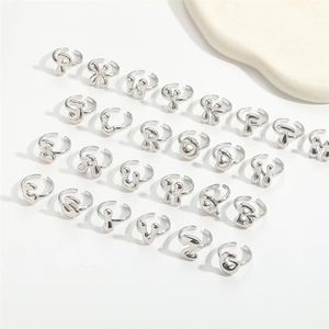 Minimalist silver initial rings with adjustable open bands in a professional grid display