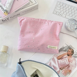 Detail of pink and blue star sequin makeup bags with silver zippers and canvas texture