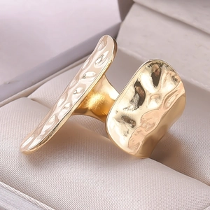 Detailed close-up of golden irregular textured ring with a modern hammer-finished design