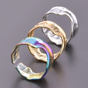 Detailed macro view of three irregular textured rings in silver, gold, and rainbow finishes