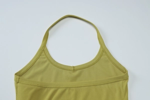 Vue macro de la maille côtelée vert moutarde et détails de couture du dos nu