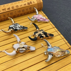 Five colorful acrylic bull head pendants with stone textures on a bamboo background