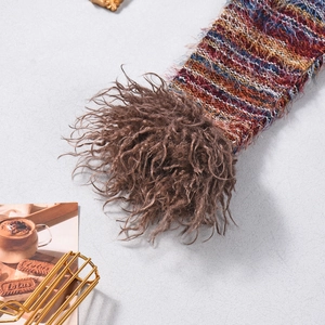 Detailed close-up of colorful knit fabric with soft faux fur cuffs on a V-neck crop top