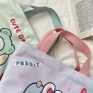 Detail of canvas tote bags with cute cartoon prints and sturdy colorful webbing handles