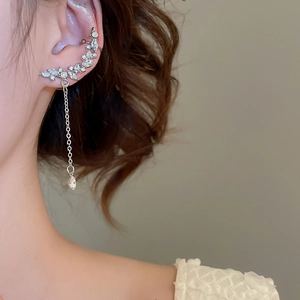 Close-up of sparkling rhinestone water drop tassel ear cuff and silver needle earrings